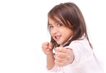Young girl smiling in self-defense pose