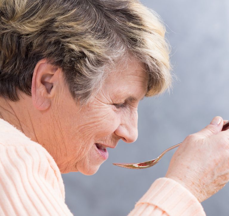 Older woman eating soup